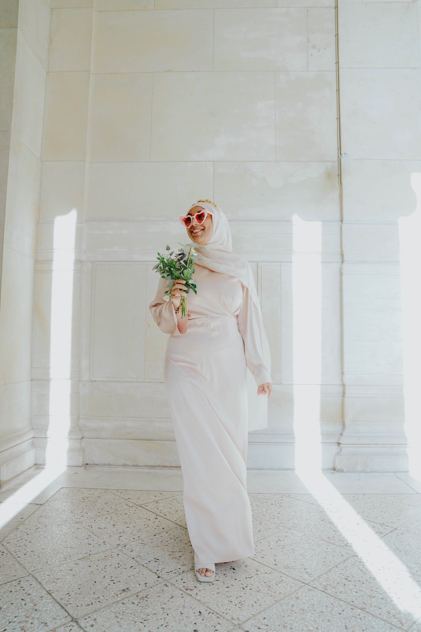 Robe en satin russe couleur nude rosé avec croisé à la taille. Manches longues évasées