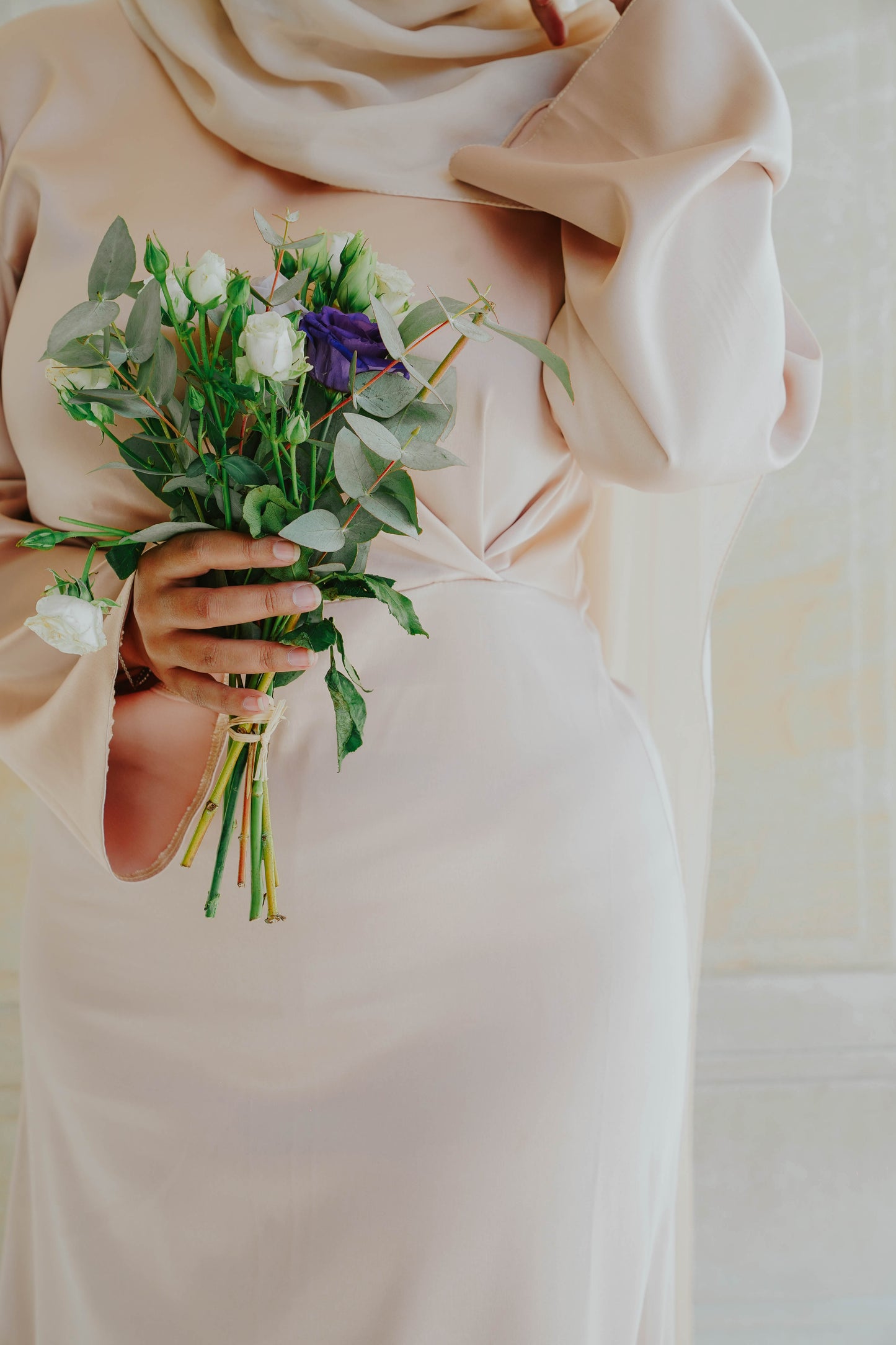 Robe en satin russe couleur nude rosé avec croisé à la taille. Manches longues évasées