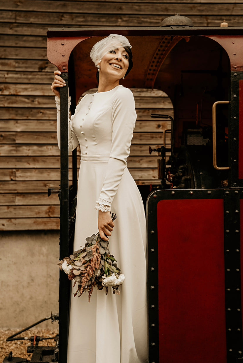 Robe coupe évasée en crêpe assez fluide et sobre, avec une traîne légère