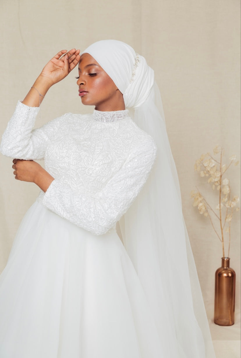 Robe en tulle et buste en dentelle perlée, col haut, manches longues opaques